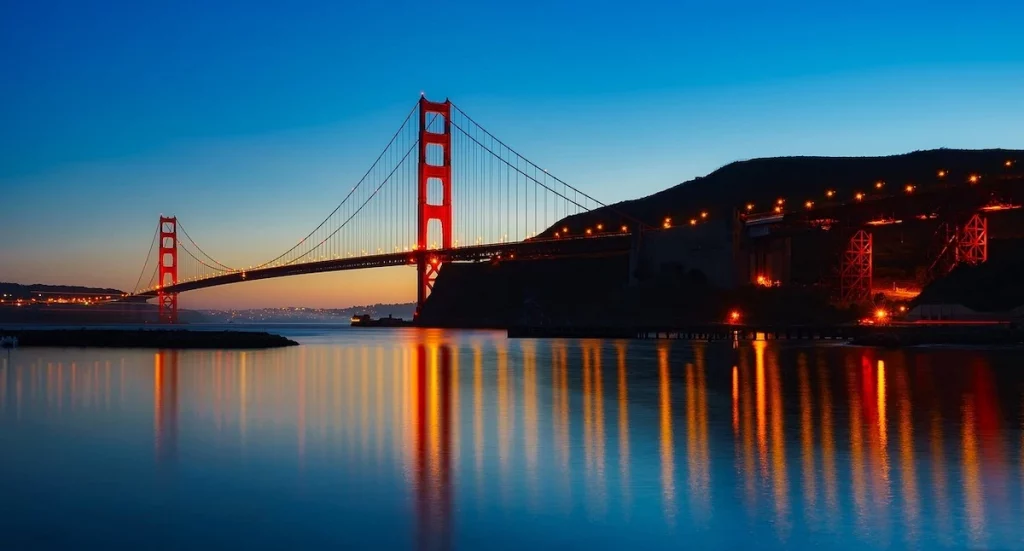 The Golden Gate Bridge with a low setting sunset over the bay