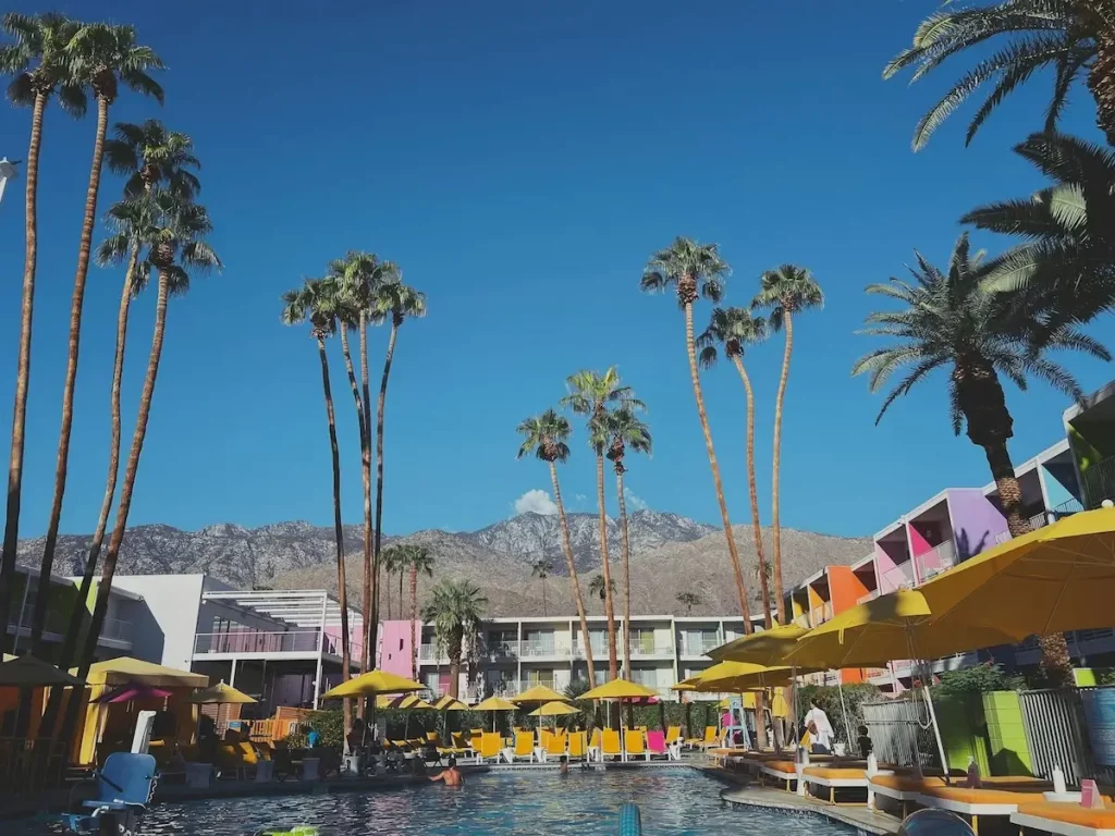 A swimming pool surrounded by a brightly-colored hotel