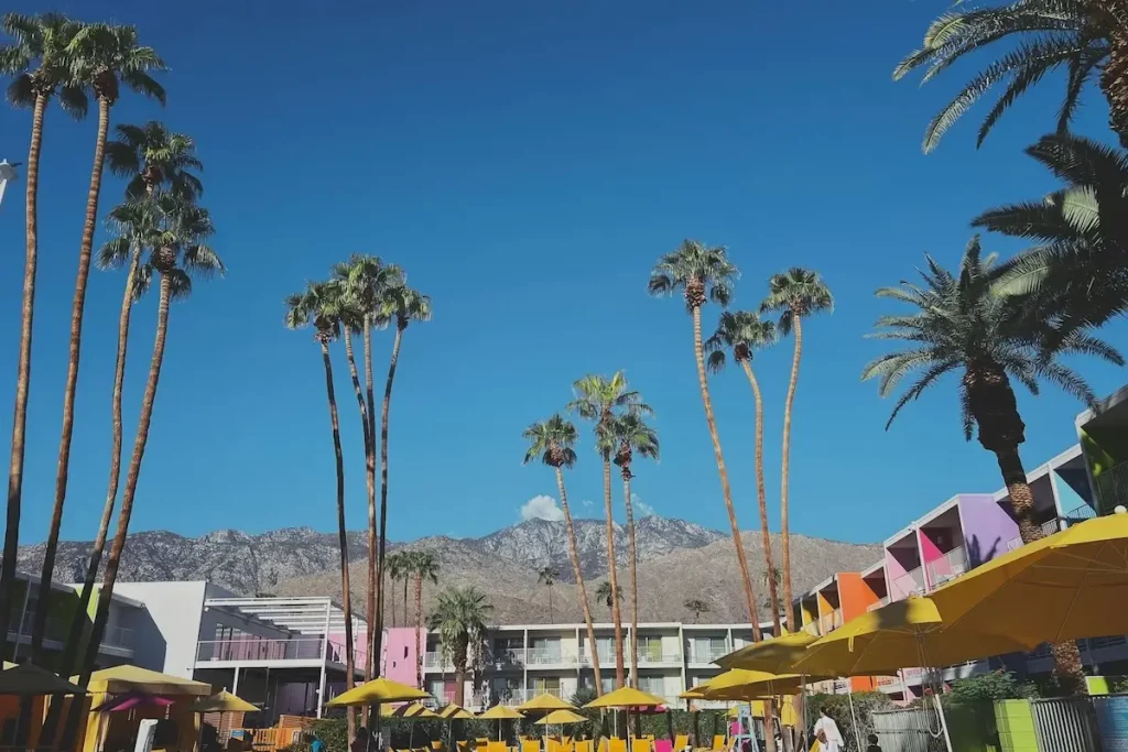 A swimming pool surrounded by a brightly-colored hotel