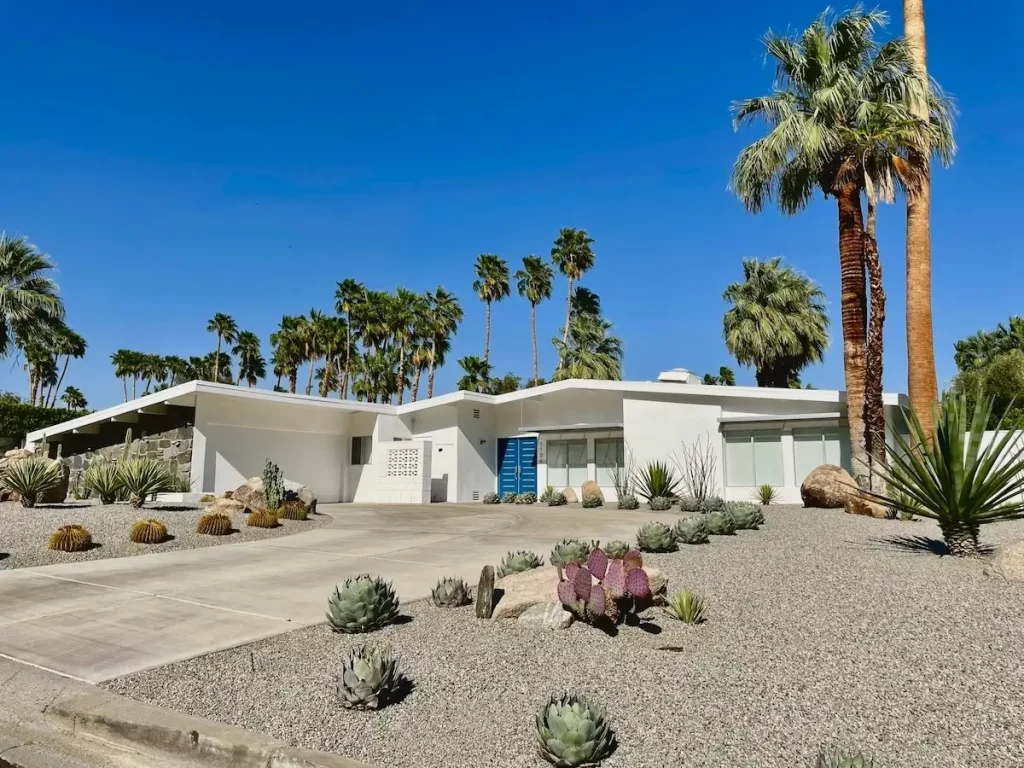 White mid century modern hone with a blue door in Palm Springs