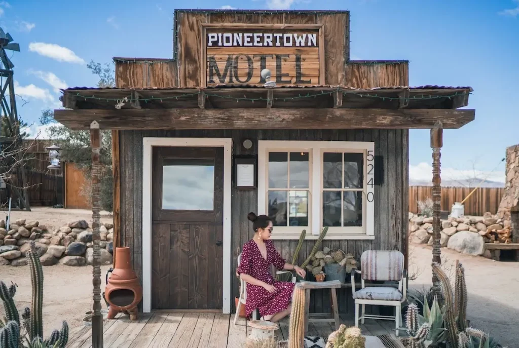 A young woman sitting in front of the Pioneertown Motel