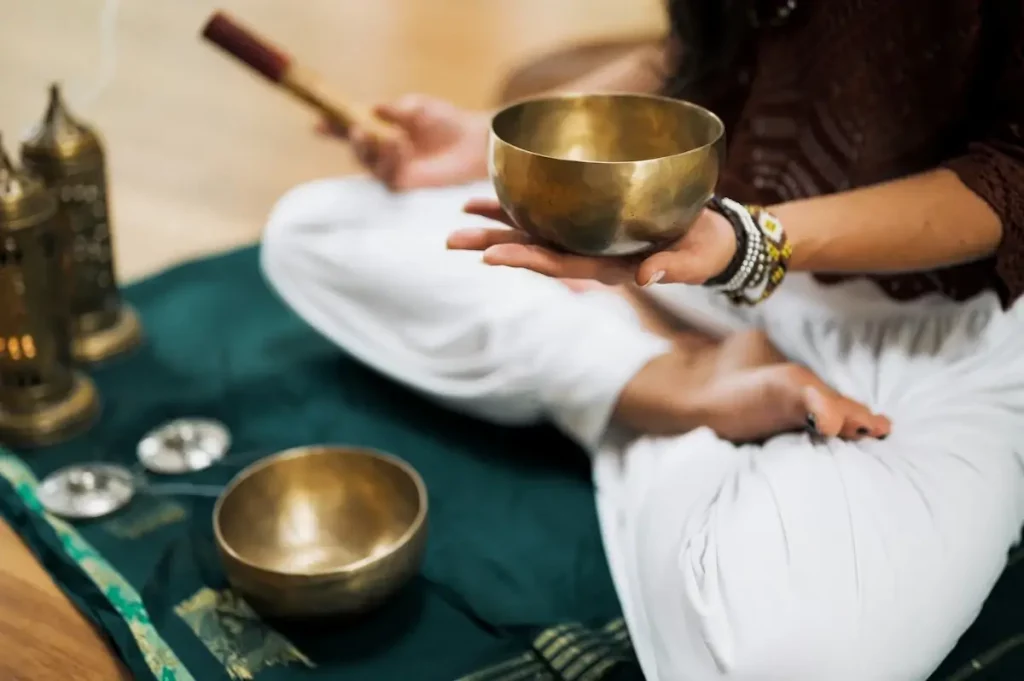 brass sound bowls with a person sitting cross legged