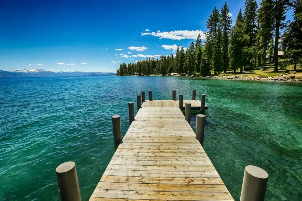 A wooden pier jetting straight out into emerald green waters of the west shore