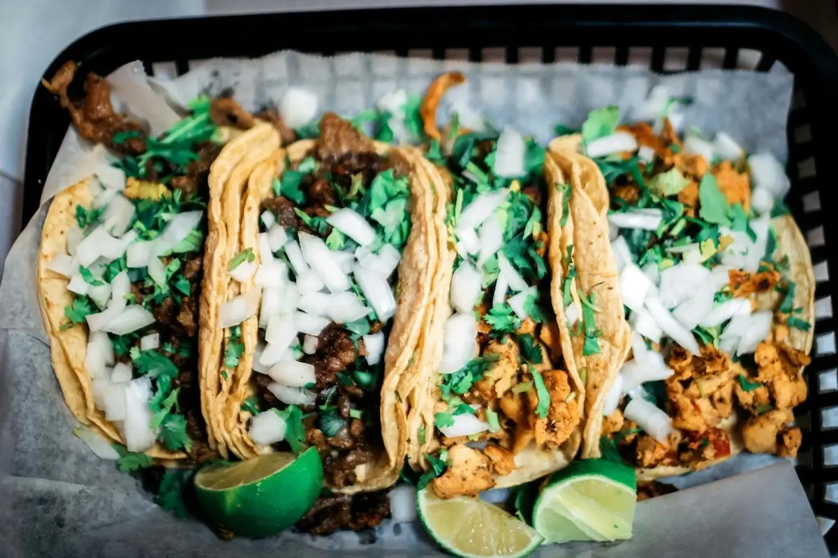 Four street tacos in a plastic basket