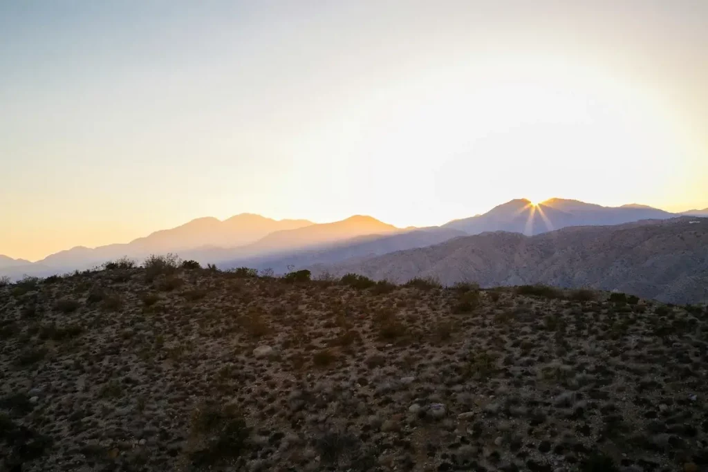 The sun setting over the mountains of the desert